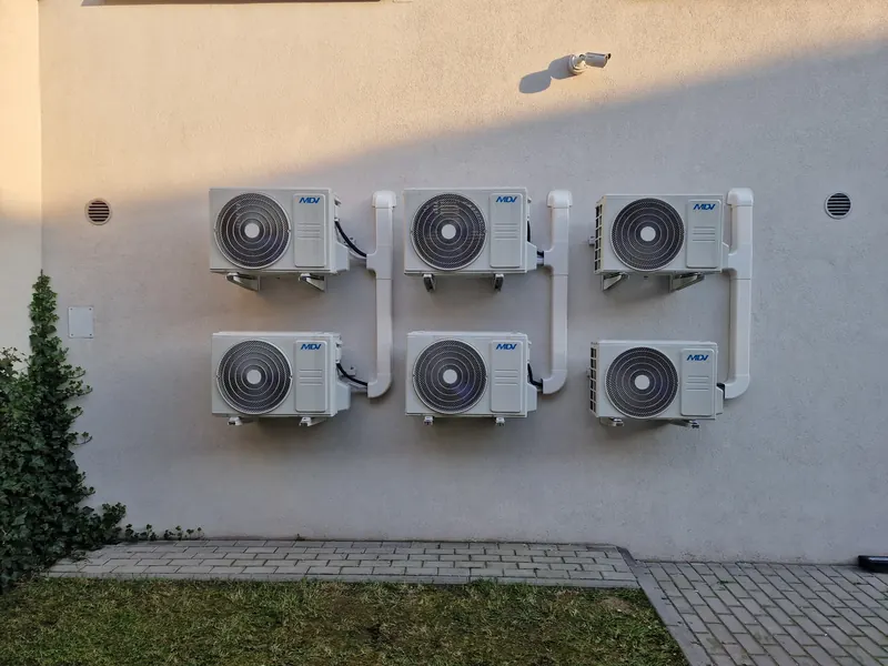 Sześć jednostek zewnętrznych klimatyzacji na elewacji budynku firmowego